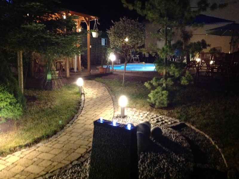 Beleuchteter Weg im Saunagarten am Abend