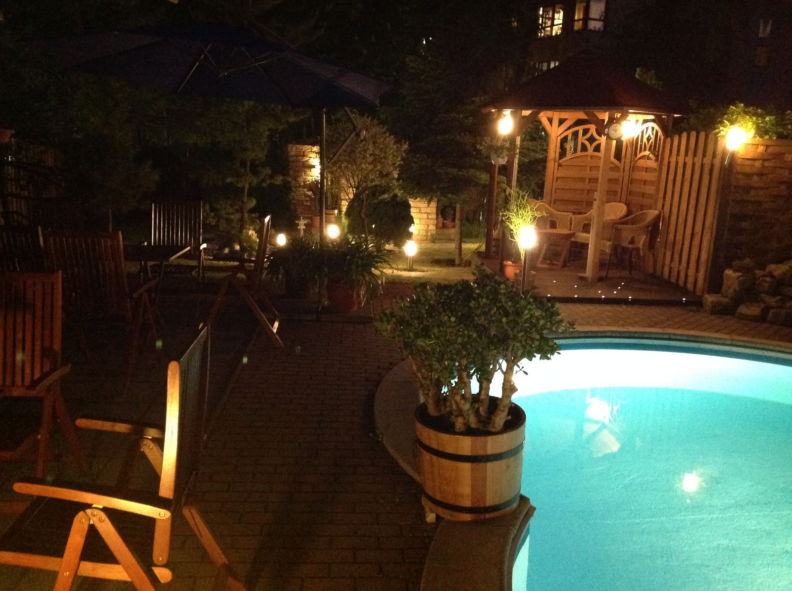 Beleuchteter Saunagarten mit beheiztem Pool bei Nacht