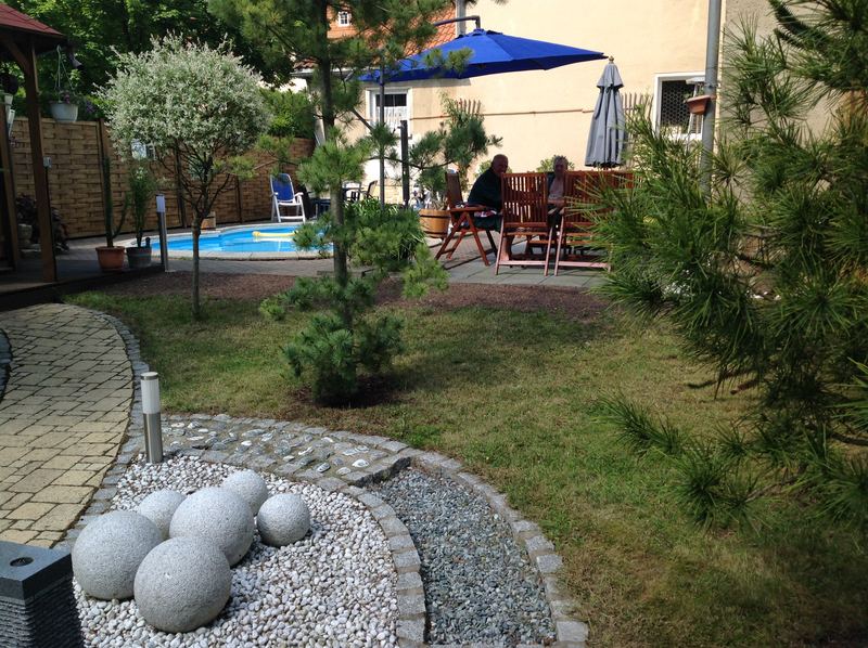 Saunagarten mit Pool und Sonnenschirmen